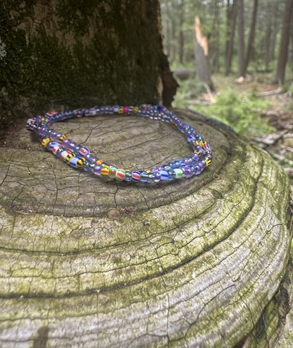 Finished bead piece — purple millefiori necklace on tree stump